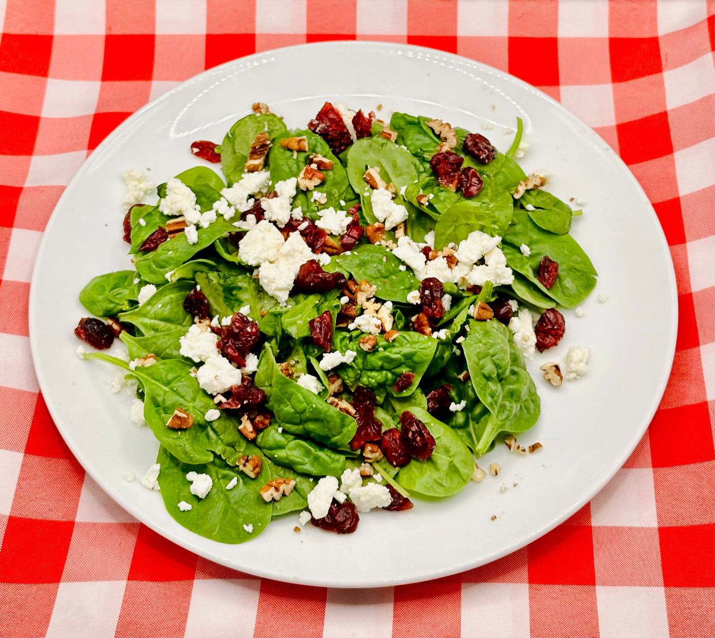 Ensalada de espinacas con queso de cabra, nueces y arándanos.